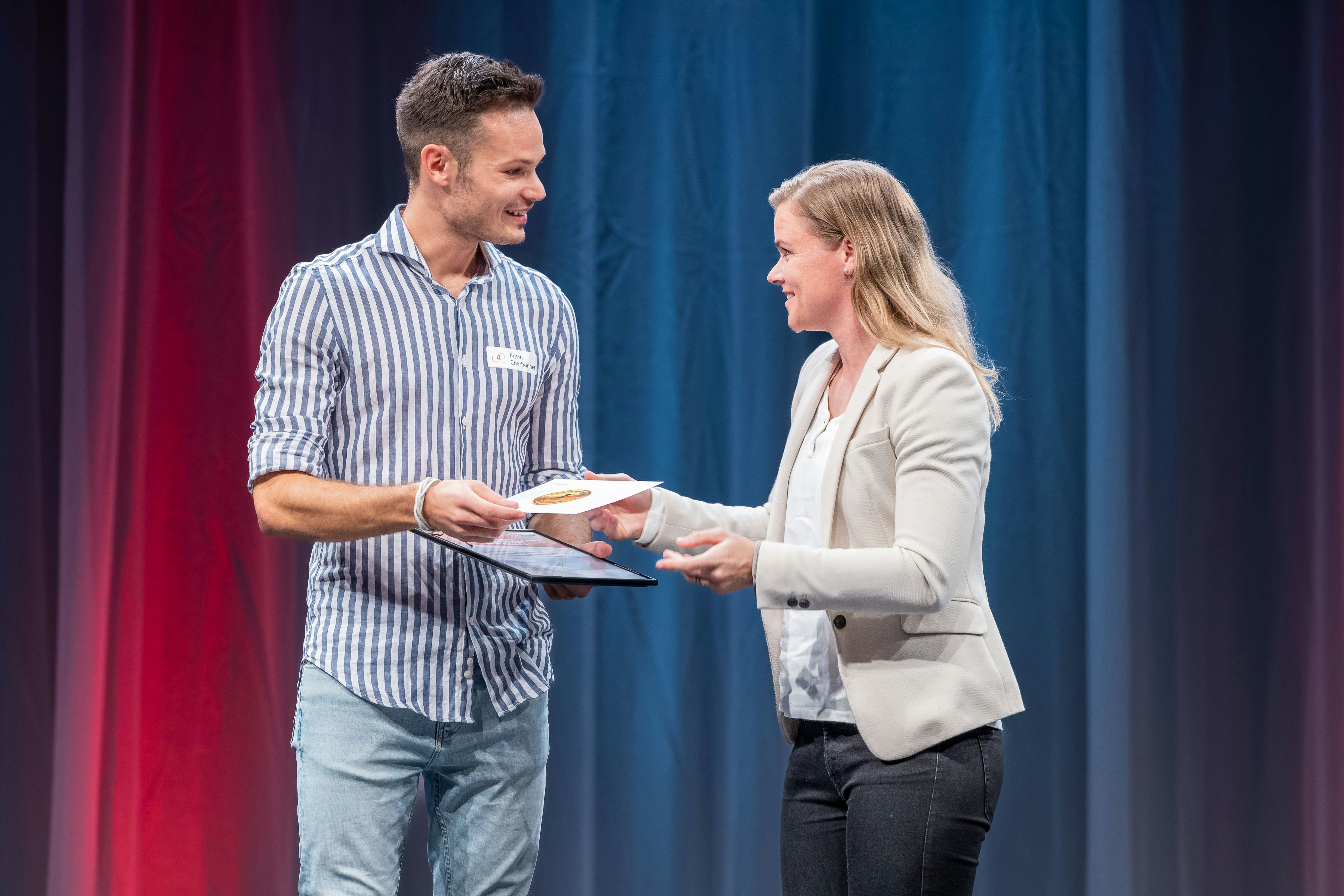 Bryan Charbonnet, Doktorand an der Uni Bern, gewinnt den ersten Preis und erhält die Urkunde von Nicole Gassmann, Leiterin Sportwissenschaften bei Swiss Olympic.
Foto: BASPO / Ueli Känzig
