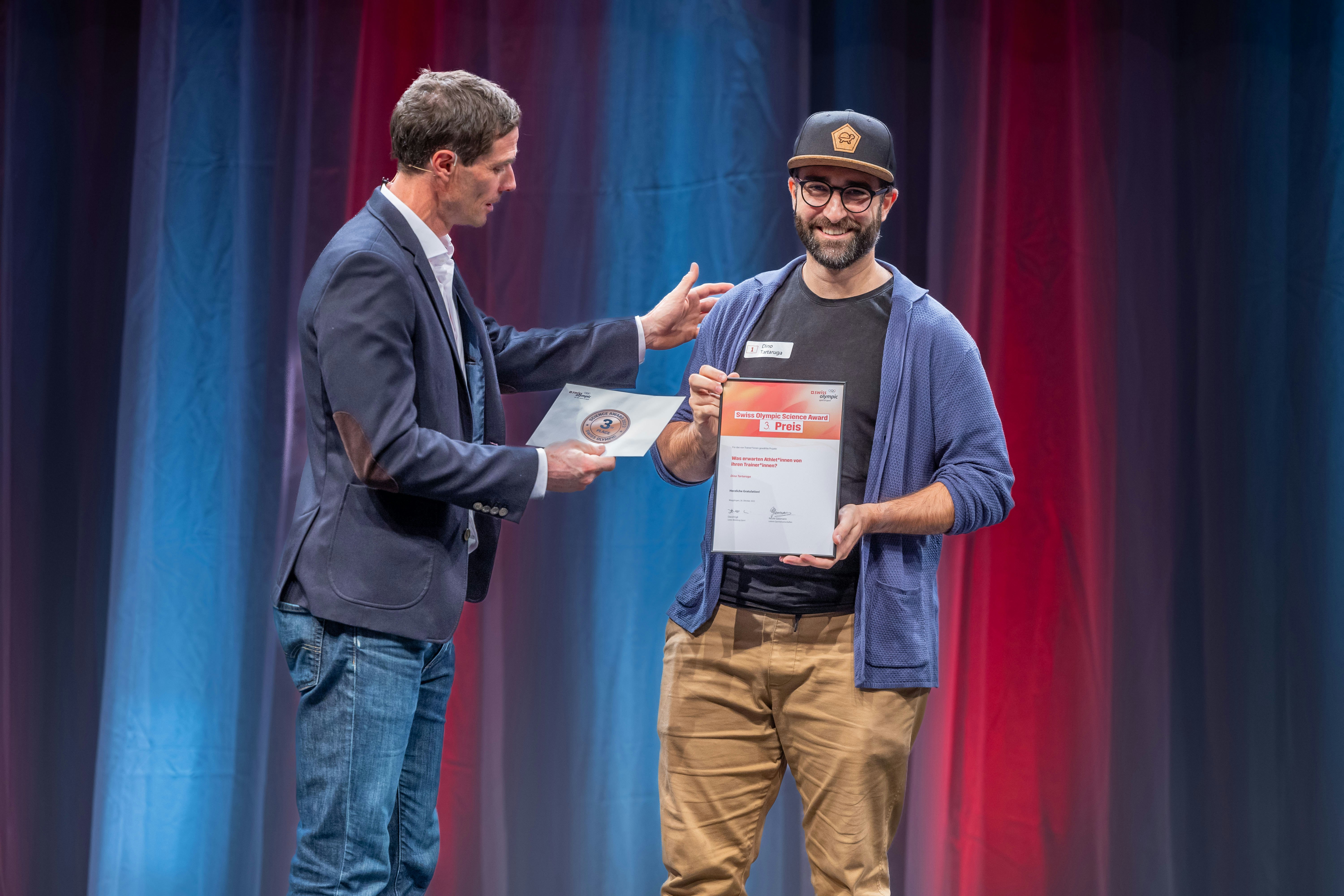Dino Tartaruga, Abteilungsleiter Sportwissenschaft und Leistungsdiagnostik bei Swiss Shooting, erhält von David Egli, Leiter Sport bei Swiss Olympic, den dritten Preis.